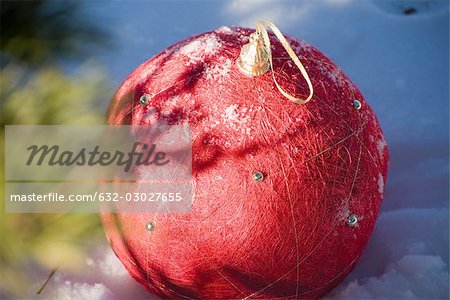 Red Christmas ornament on snowy ground