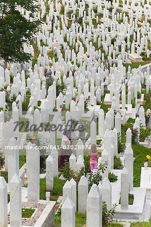 Femme et enfant tendent une tombe dans le cimetière de guerre, Sarajevo, Bosnie, Bosnie-Herzégovine, Europe