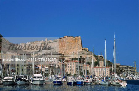 Yachts moored in the harbour, with waterfront and the citadel behind, Bonifacio, island of Corsica, France, Mediterranean, Europe
