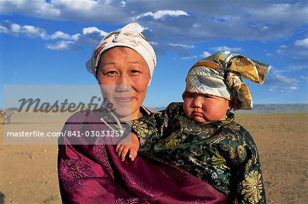 Head and shoulders portrait of a smiling nomad woman and child in traditional clothing, looking at the camera, at Naadam Festival, Altai, Gov-altai, Mongolia, Central Asia, Asia