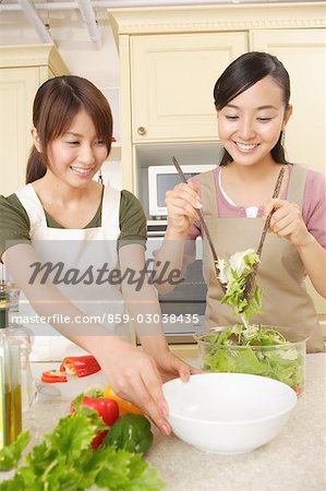 Front view of young women pouring salad