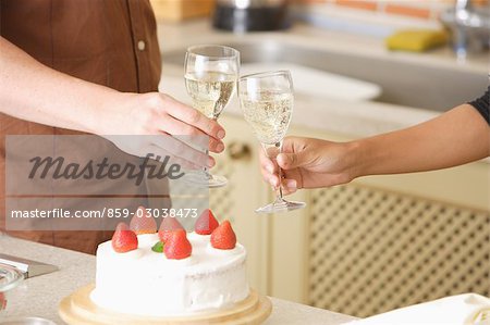 Close-up Hände von Menschen feiern mit Champagner und Erdbeeren Kuchen