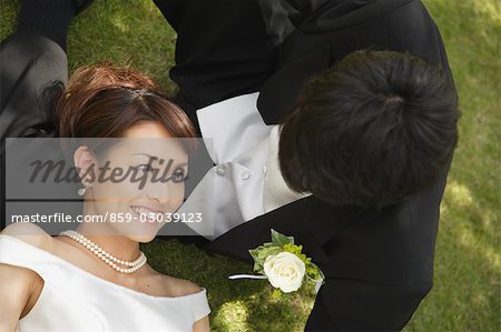 Bride and Groom Laying on Grass