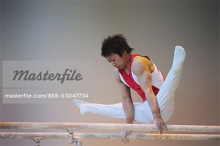 Young gymnast balancing on parallel bars