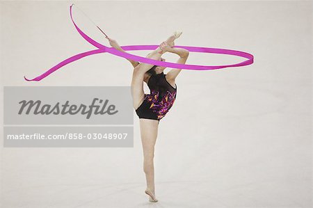 Une jeune fille jouant de gymnastique rythmique avec jambe soulevée