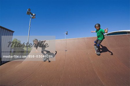 Skateboarders skating in skate park