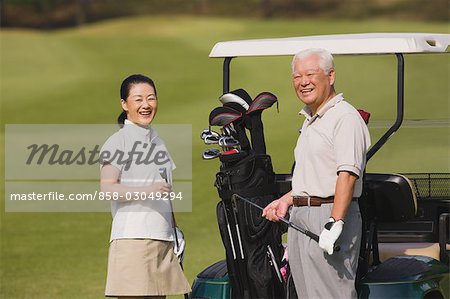 Golfeurs en souriant et en regardant la caméra