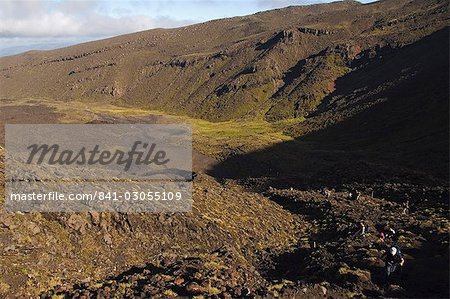 Hikers walking through a lava field on the Tongariro Crossing, Tongariro National Park, the oldest national park in the country, UNESCO World Heritage Site, Taupo Volcanic Zone, North Island, New Zealand, Pacific