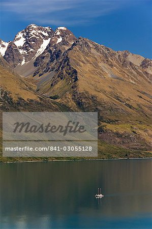 A tiny sail ship on the mountain edged Lake Wakatipu near Queenstown, Otago, South Island, New Zealand, Pacific