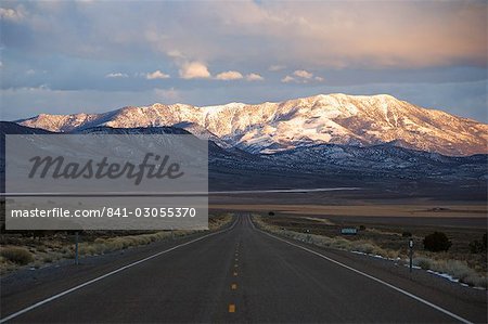 Snow capped mountains on a straight road of American south west, U.S. Route 50, the loneliest road in America, Nevada, United States of America, North America