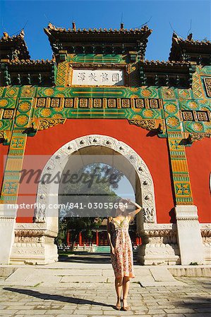 Chinese girl under a glazed archway at the Confucius Temple Imperial College, built in 1306 by the grandson of Kublai Khan, administering the official Confucian examination system, Beijing, China, Asia