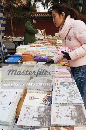 Eine chinesische Mädchen auf der Suche nach Büchern im Ditan Park Buch Messe, Peking, China, Asien