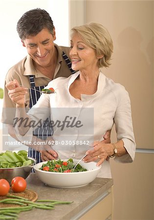 Couple d'âge mûr dans la cuisine en salade