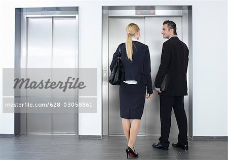 Businessman and businesswoman waiting for elevator