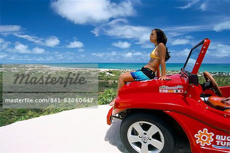 Young woman sitting on dune buggy, Pitangui, Natal, Rio Grande do Norte state, Brazil, South America