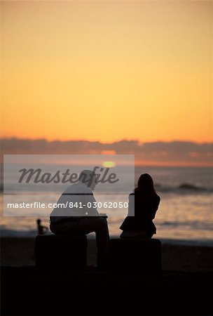 Silhouette d'un couple de regarder le coucher du soleil, la plage de Camps Bay, Cape Town, Afrique du Sud, Afrique