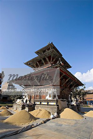 Piles of grain in front of the triple roofed pagoda of the Rato Machendranath temple, Patan, Kathmandu, Nepal, Asia