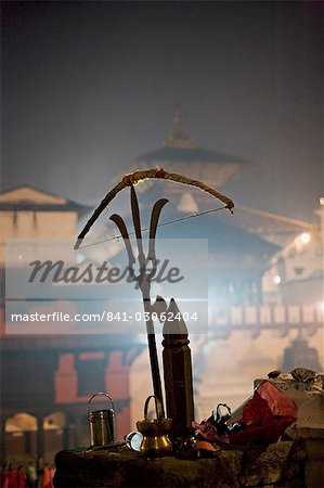 A holy man's bow placed on a bronze sculpture of a Shiva trident, Hindu festival of Shivaratri, Pashupatinath, Kathmandu, Nepal, Asia