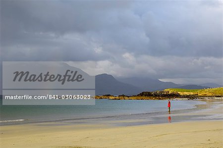 Personne seule sur une plage de sable fin sous un ciel orageux, près de Tully Cross, Connemara, comté de Galway, Connacht, Irlande, Europe