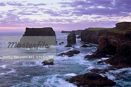 Coucher de soleil sur les falaises de basalte Eshaness, avec la pile de Moo sur le côte gauche et profondément érodée avec des grottes, des évents et des piles, Northmavine, îles Shetland, Ecosse, Royaume-Uni, Europe Coucher de soleil sur les falaises de basalte Eshaness, avec la pile de Moo sur le côte gauche et profondément érodée avec des grottes, des évents et des piles, Northmavine, îles Shetland, Ecosse, Royaume-Uni, Europe