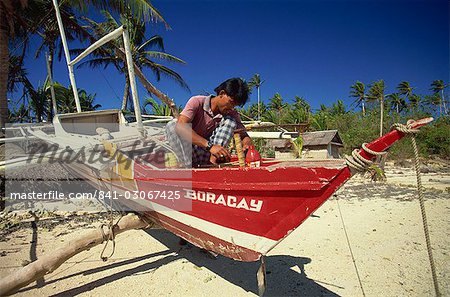 Man painting outrigger boat on Boracay island, off Panay, Philippines, Southeast Asia, Asia