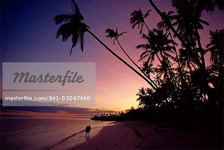 Couple des palmes sur la plage d'Alona silhouette au coucher du soleil sur l'île de Panglao, au large de la côte de Bohol, Philippines, Asie du sud-est, Asie