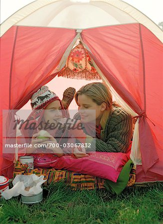 Mère et fille de manger à l'intérieur de la tente