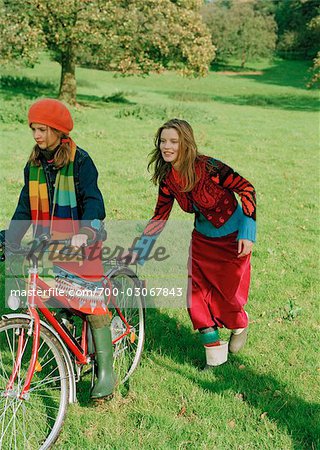 Mother pushing Daughter on Bicycle