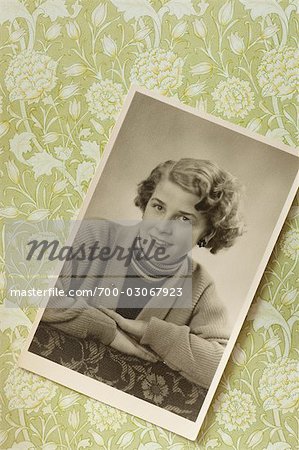 Schwarz-weiß-Fotografie von Portrait der Frau in den 1950er Jahren, gegen Floral Tapete