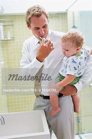 Père Holding Baby et le brossage des dents