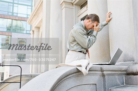 Homme d'affaires avec ordinateur portable à l'extérieur