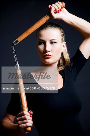 Femme tenant des nunchakus