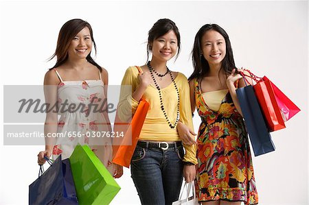 Trois femmes tenant des sacs à provisions.