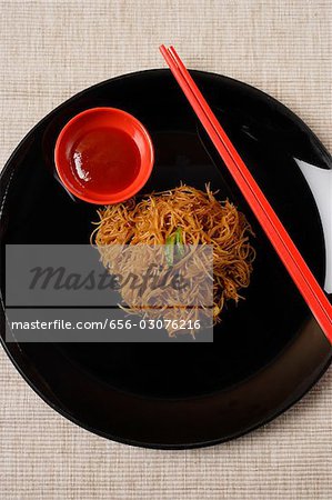 Noodles on plate with chopsticks.