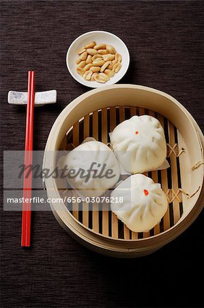 Steamed buns in bamboo steamers with red chopsticks