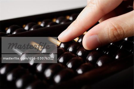 close up of hand touching abacus