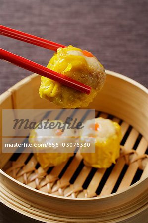 red chopsticks holding dim sum