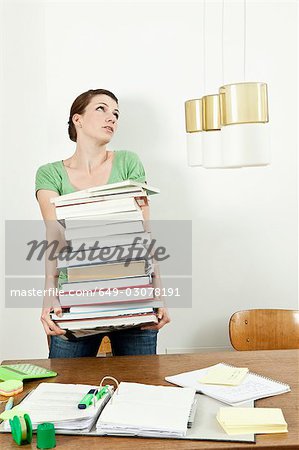 Female student carrying stack of books