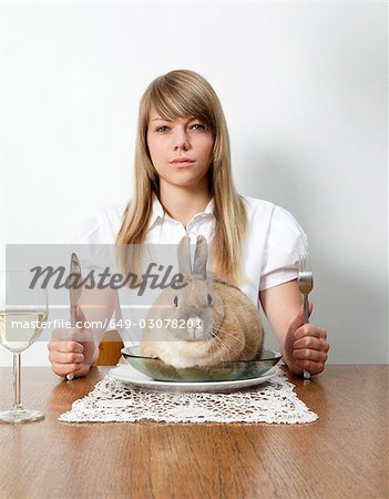 Frau mit lebenden Kaninchen auf ihrem Teller