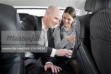 homme et femme dans la voiture avec ordinateur portable