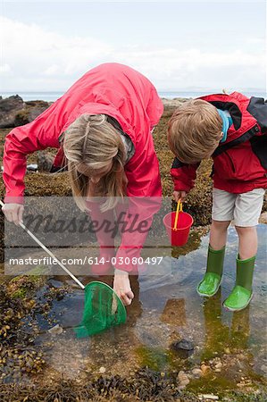 Mother and son looking in rock pool