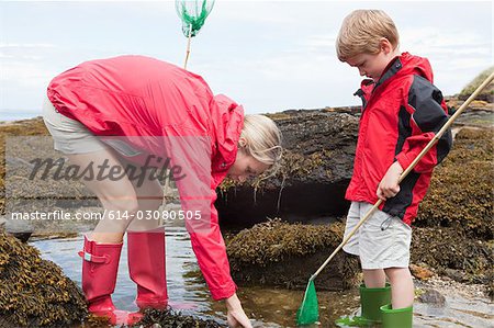 Mother and son looking in rock pool