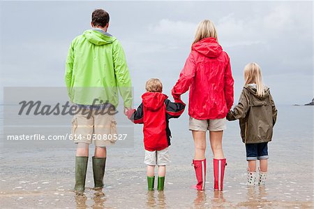 Family holding hands in the sea