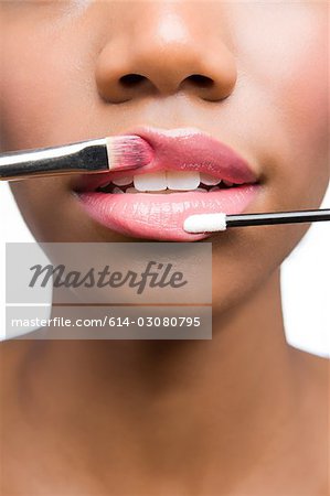 Woman having lipgloss applied