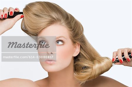 Junge Frau mit Haarbürsten