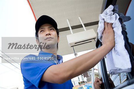 Station-service commis essuyer la fenêtre de la voiture