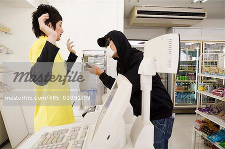 Robber threatening convenience store clerk