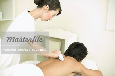 Massage therapist applying body massage