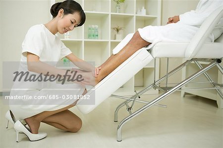 Massage therapist applying foot massage