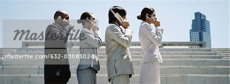 Professionell gekleidete Männer und Frauen in Linie mit sukzessive erweiterte Telefone